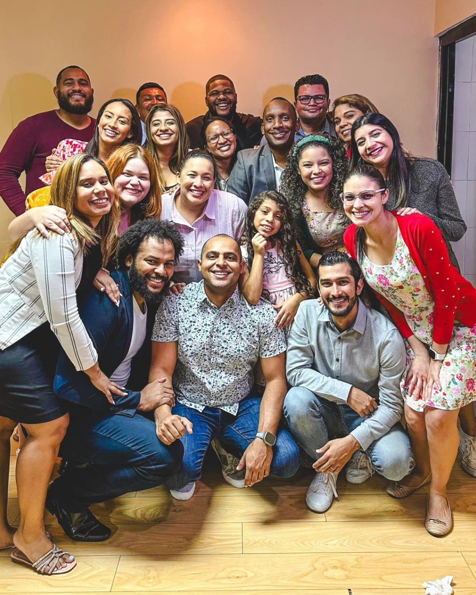Toda la comunidad de reVIVE reunida y sonriendo en el salón después del culto